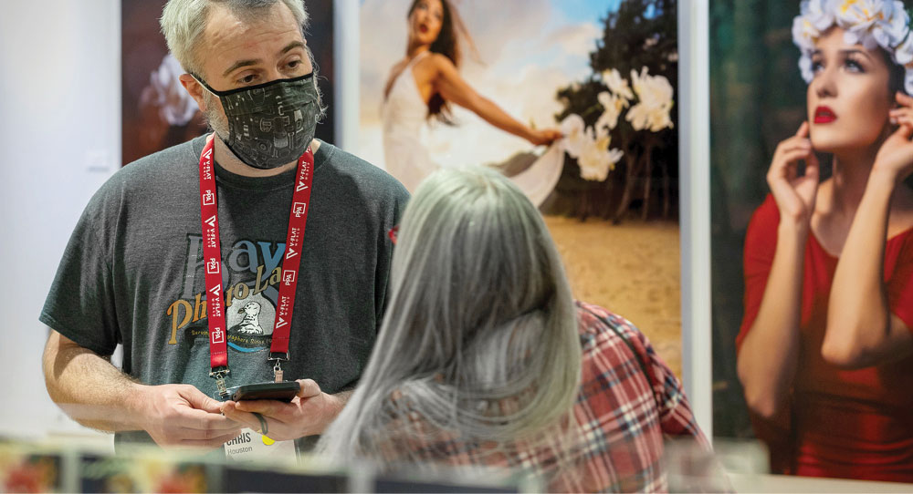 Customer talking to Bay Photo employee among Prints